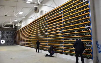 Rows of mining rigs operating inside a professional mining farm